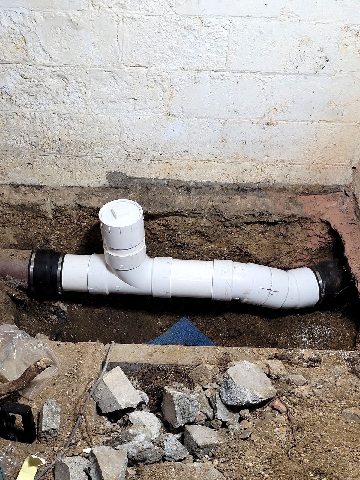 Sewer line repair with new PVC pipe in an excavated floor