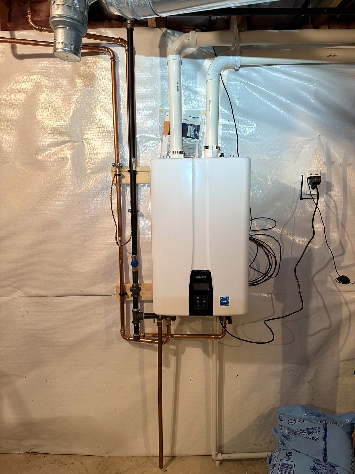 Tankless water heater installed on a basement wall